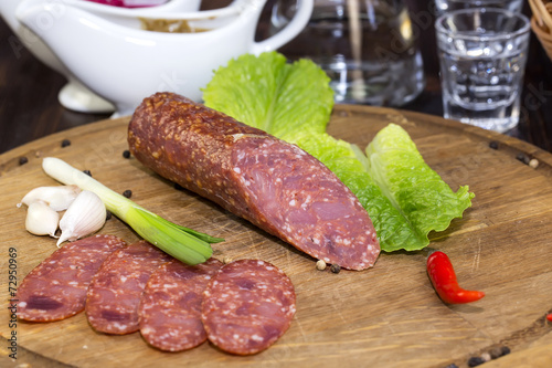 sausages on a wooden plate with vegetables in a restaurant