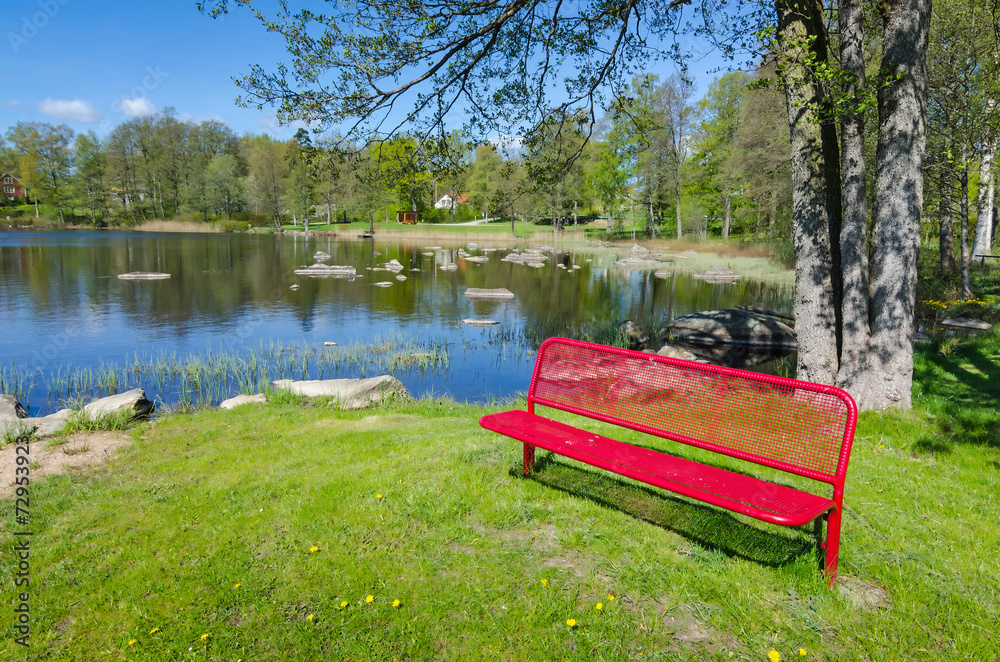 Obraz premium Red bench in spring natural scenery