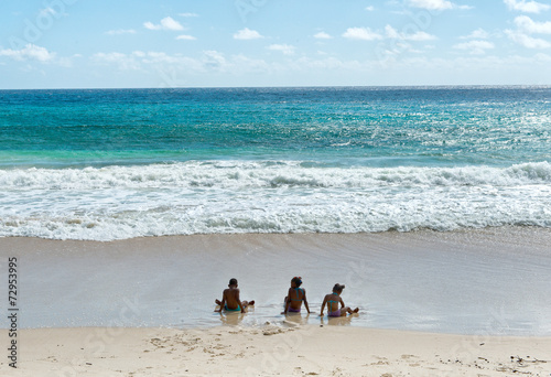 Tourist Sitting on Sand at Seychelles Island Beach