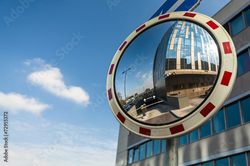 Фотография Convex mirror at a street reflecting a barrier entrance in under