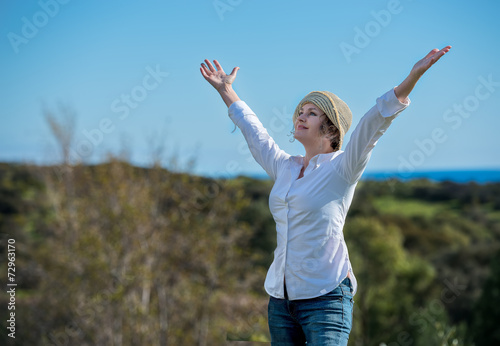 Woman in nature with arms outstretched