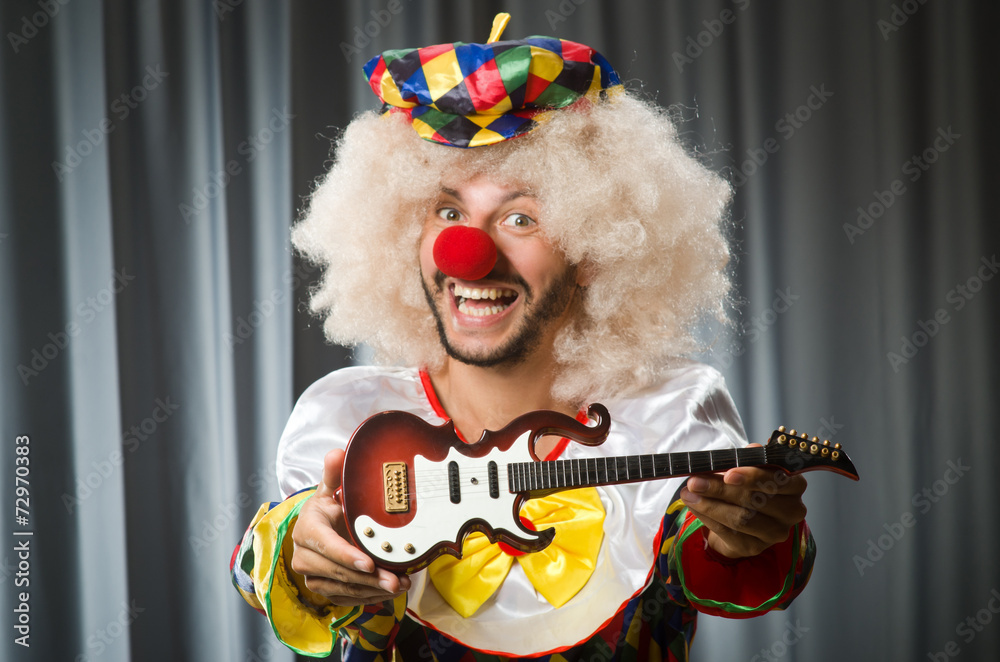 Angry clown with guitar in funny concept Angry clown with guitar in funny concept