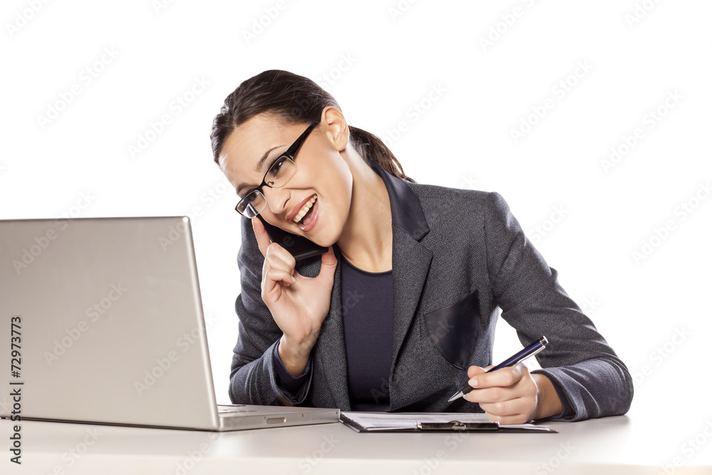 business woman talking on the phone and writing in notebook business woman talking on the phone and writing in notebook