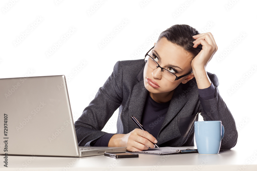 bored business woman working next to a laptop bored business woman working next to a laptop