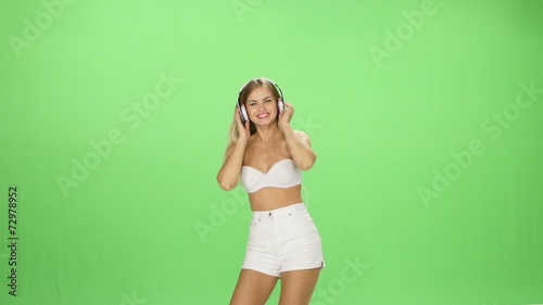Young beautiful blonde girl dancing with headphones isolated on