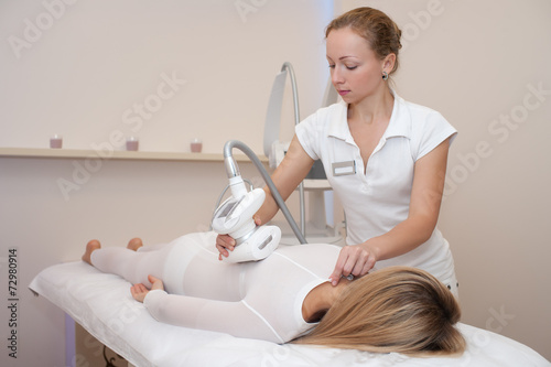 young woman on a lipomassage procedure in beauty salon