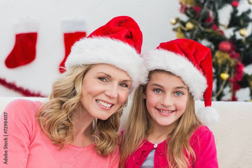 Festive mother and daughter smiling at camera