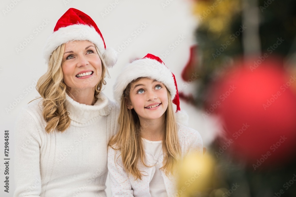 Festive mother and daughter smiling at tree Festive mother and daughter smiling at tree