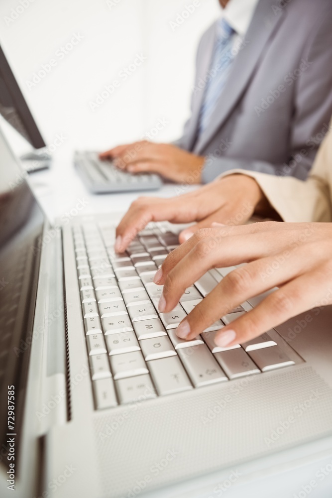Hands using computers in office