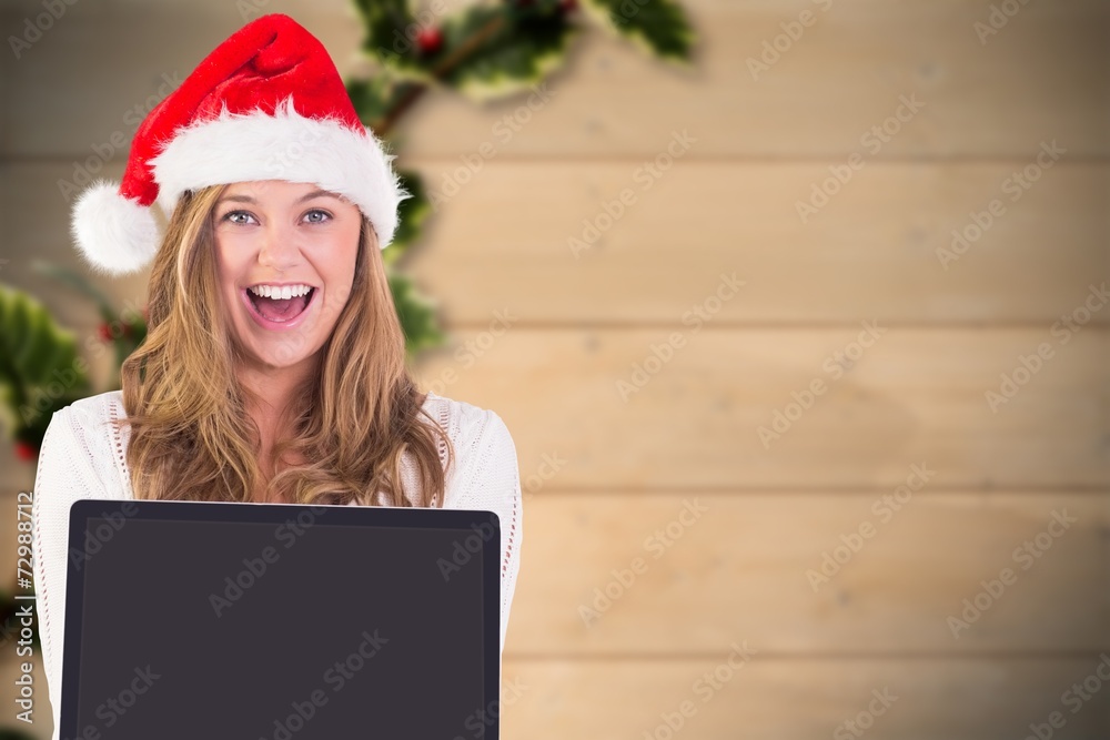 Composite image of festive blonde showing a laptop Composite image of festive blonde showing a laptop