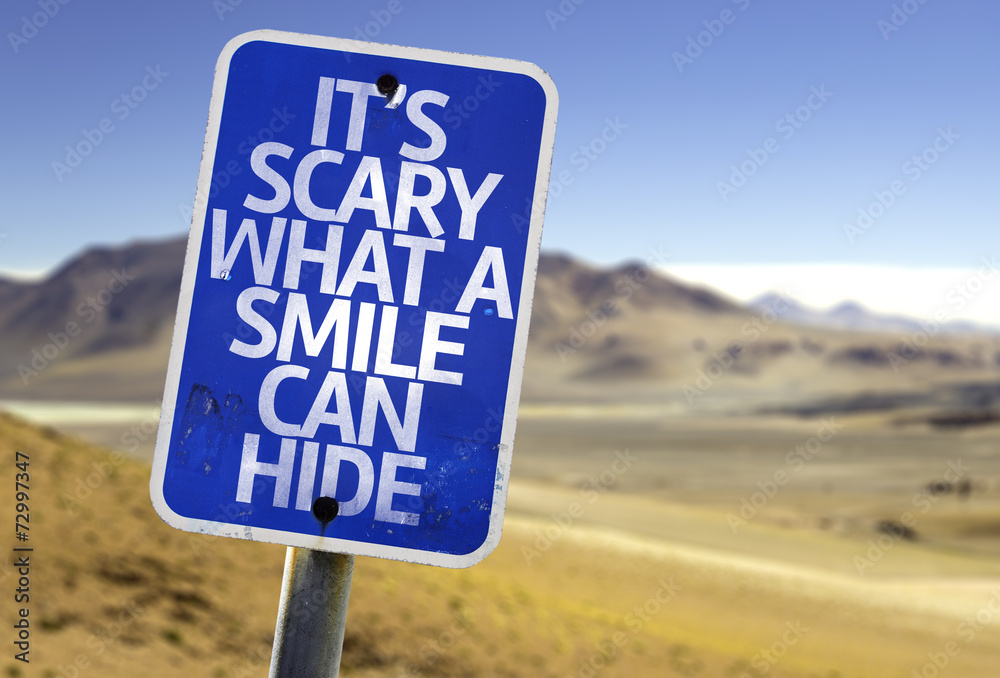 It's Scary What a Smile Can Hide sign with a desert