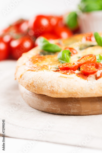 italian pizza on tablecloth with tomatoes vertical