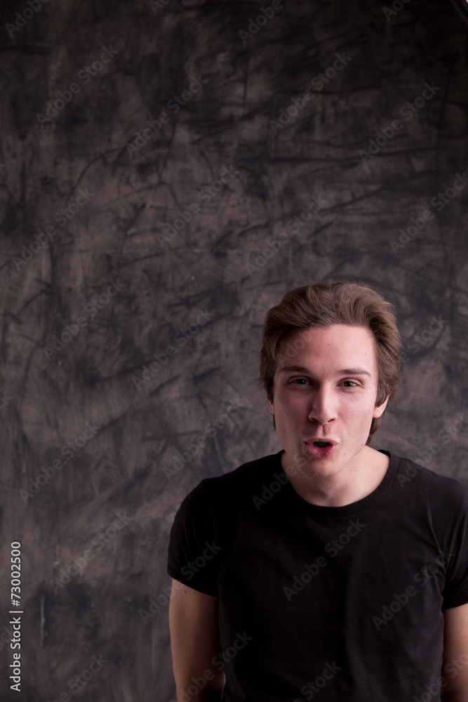 Obraz premium smiling smart guy on a grunge black background