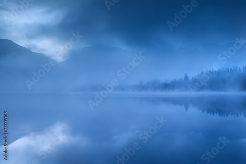 lake in Alps during misty morning