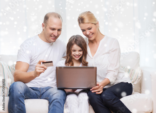 happy family with laptop computer and credit card