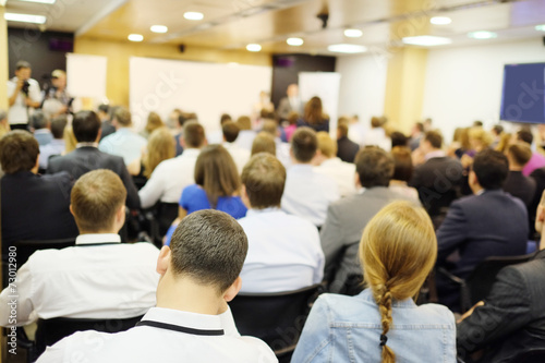 The audience listens to the acting in a conference hall