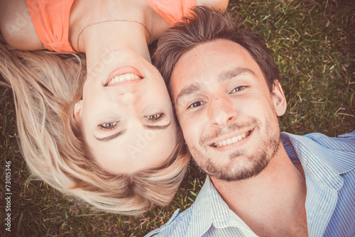 Close-up of happy couple lying on grass