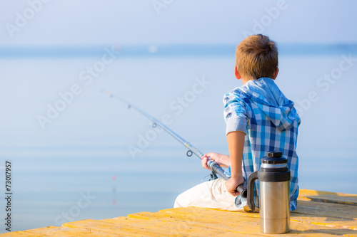 Boy in blue shirt sit on a pie