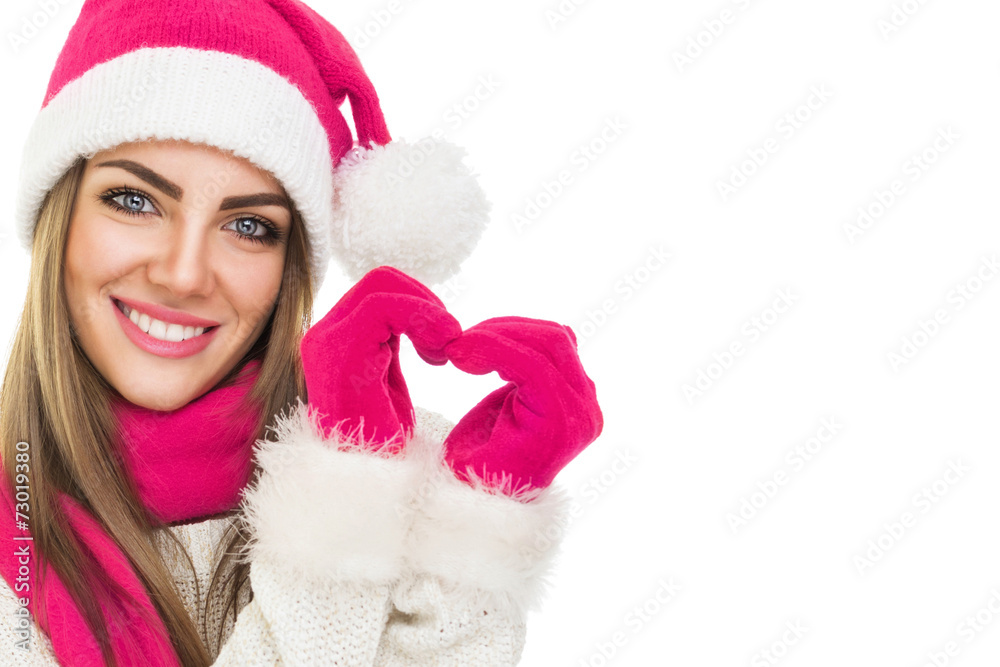 Fototapeta premium Beautiful Santa girl with hat gloves and scarf gesturing heart.