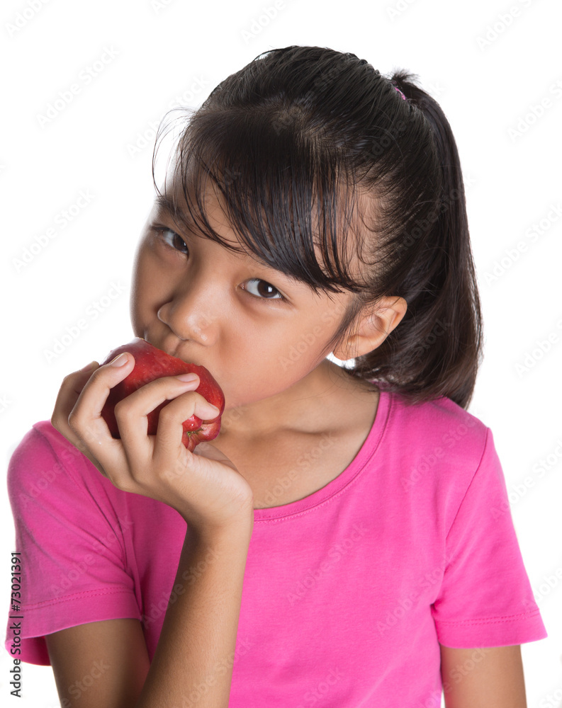 Young Asian teen eating a red apple over white background