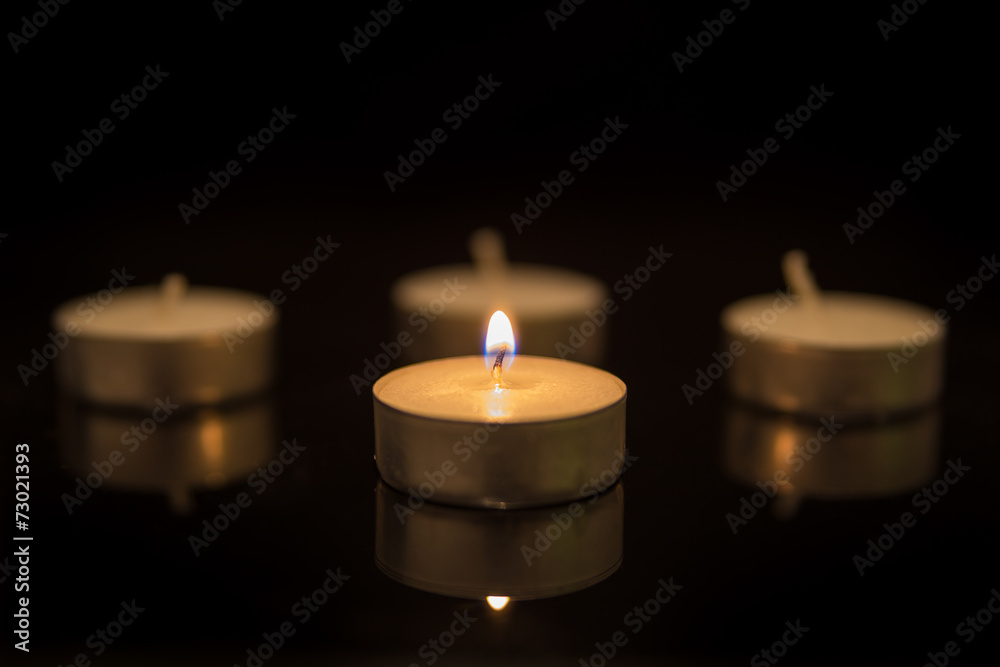 Four Tea Candles with Reflection on Black