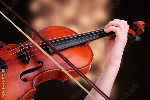 Beautiful young girl with classical violin on bright background