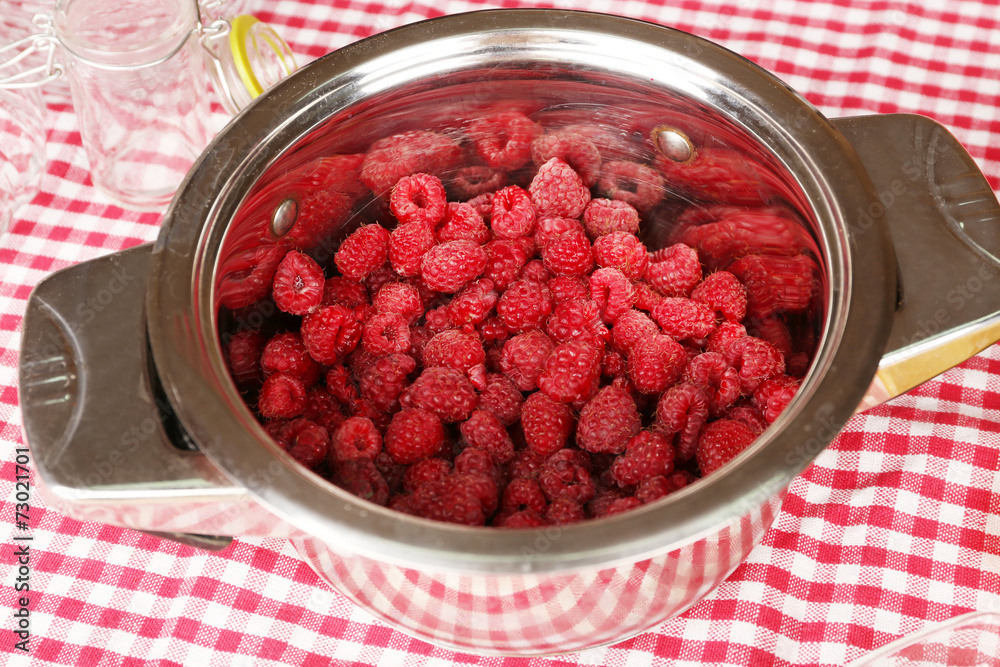 Red raspberries in metal pan on fabric background Red raspberries in metal pan on fabric background