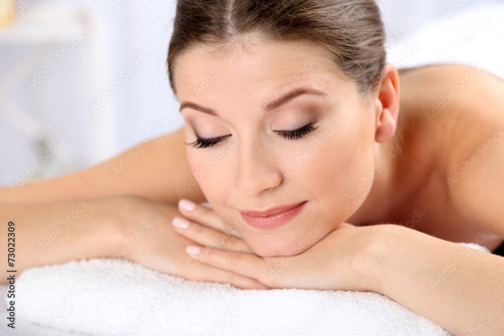 Beautiful young woman having relax in spa salon