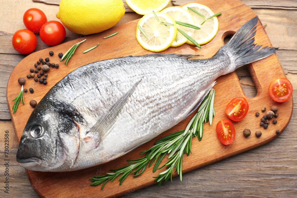Fresh raw fish and food ingredients on table Fresh raw fish and food ingredients on table