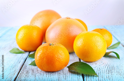 Ripe citrus with green leaves on wooden background