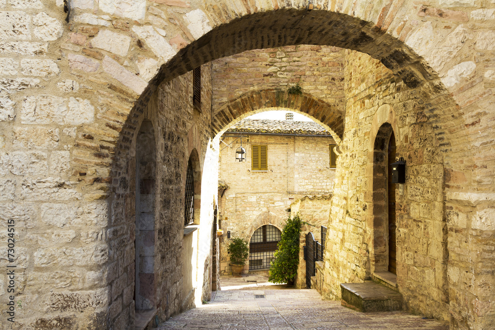 Street with arches in an old town from Tuscany
