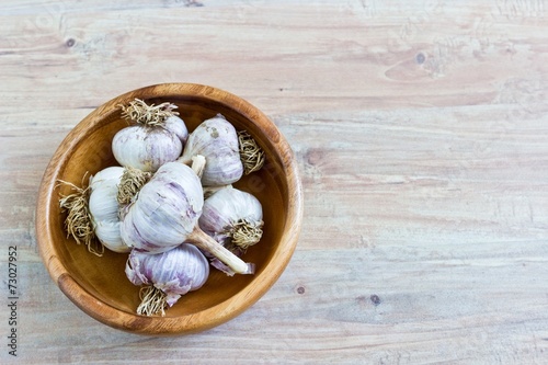 Fresh garlic in wooden bowl. Horizontal image