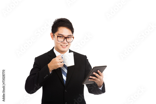 Asian businessman with a cup of coffee and tablet PC