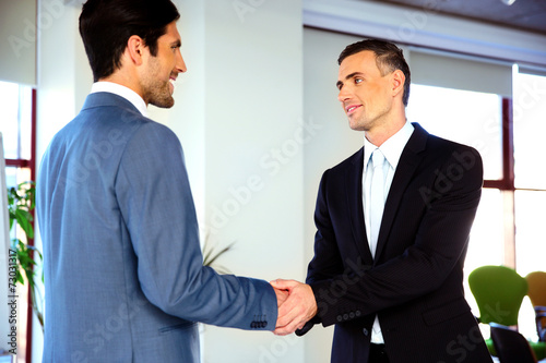 Two smiling businessman handshaking