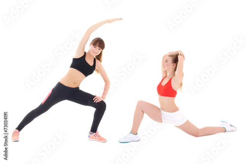 two slim sporty women doing stretching exercises isolated on whi