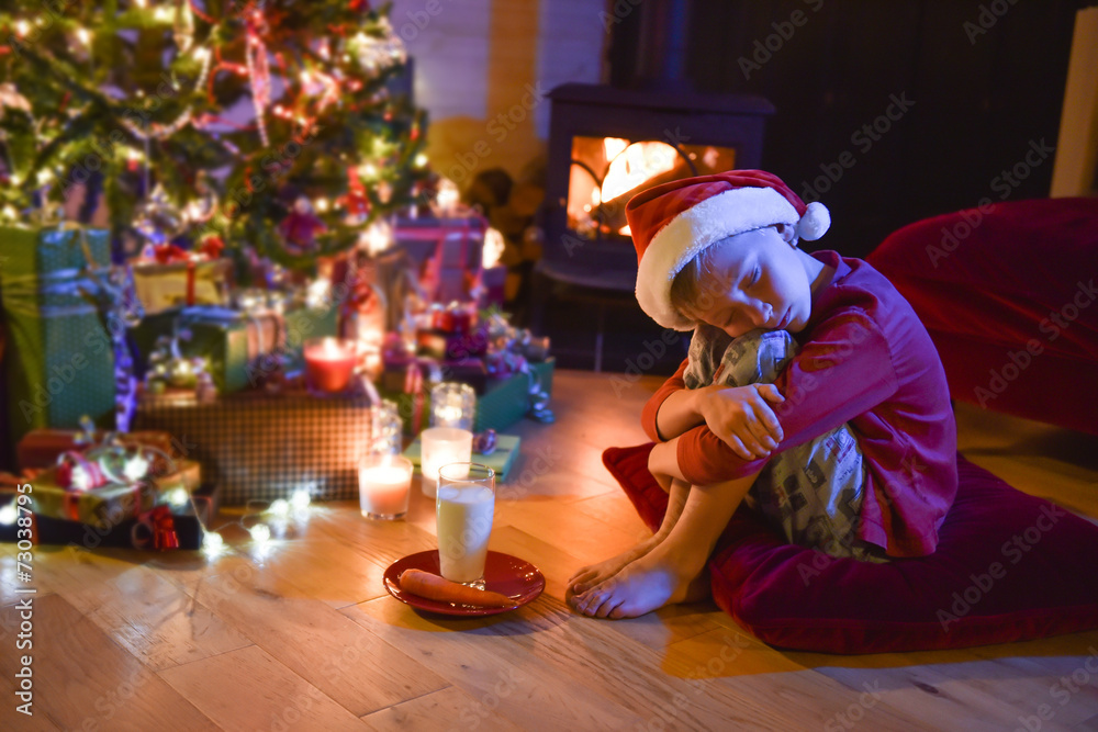 A little boy fell asleep while waiting for Santa Claus in front