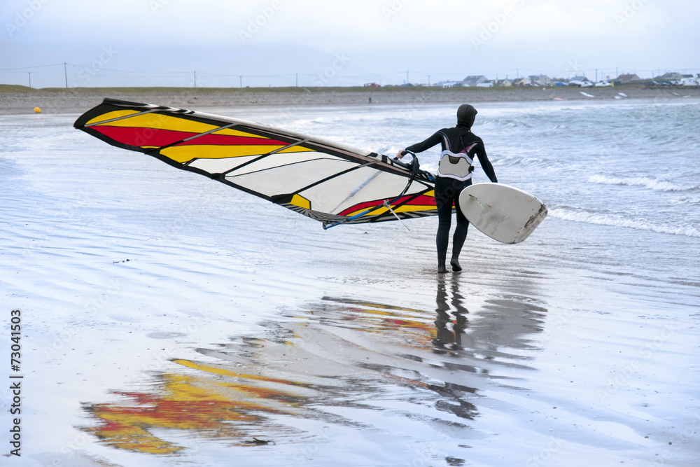 Naklejka premium lone windsurfer getting ready to surf