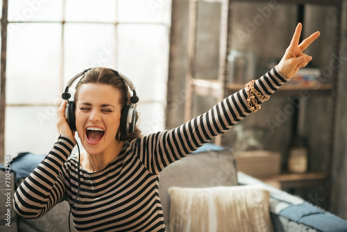 Konstfotografi Cheerful young woman listening music in headphones