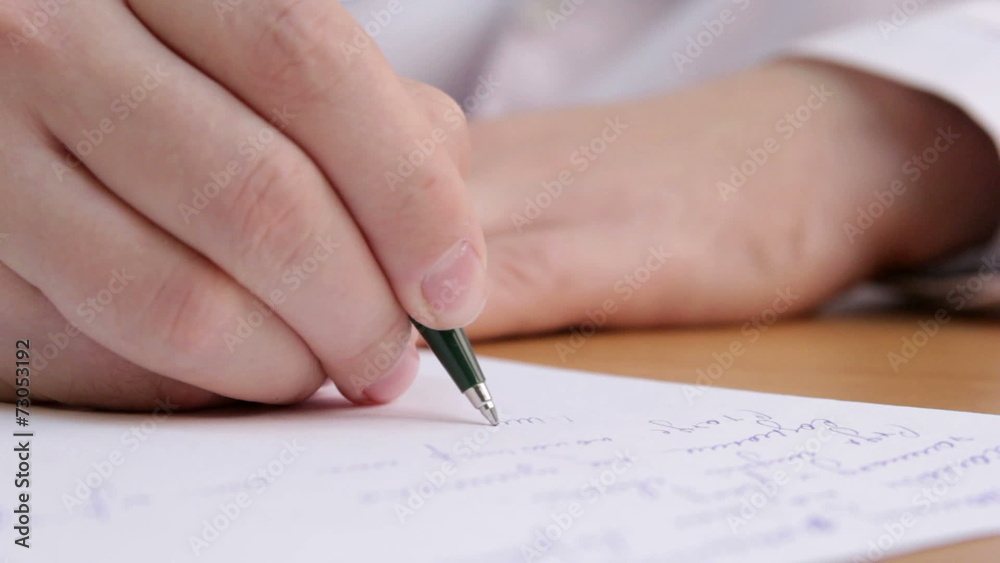 The doctor writes a diagnosis in the medical record close up The doctor writes a diagnosis in the medical record close up