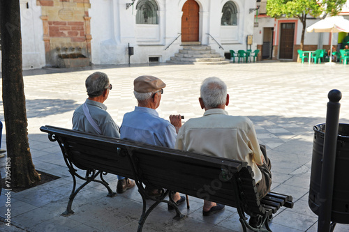 Three old men sitting on the bench, Spanish village photo