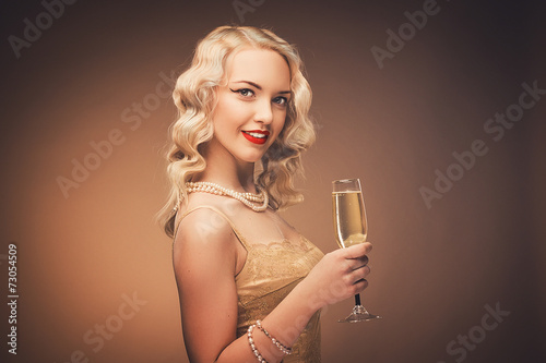 Vintage portrait of a girl with champagne. Blonde in studio.