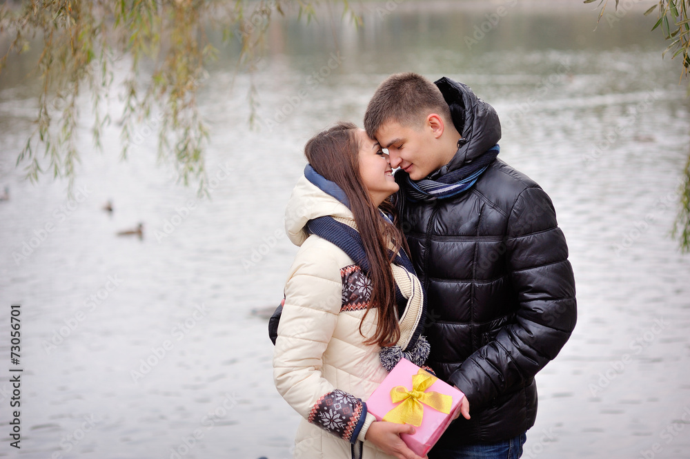 Image of affectionate guy kissing his girlfriend while giving he Image of affectionate guy kissing his girlfriend while giving he