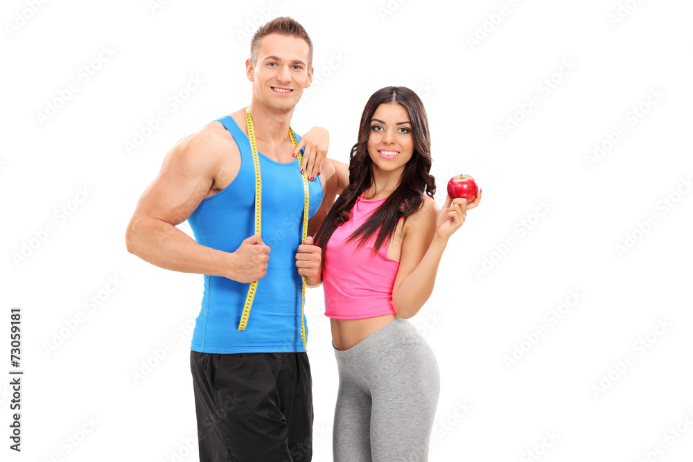 Active young couple posing with an apple Active young couple posing with an apple