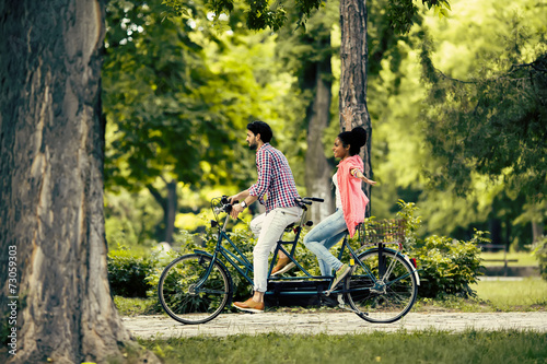 Young couple riding on the tandem bicycle © BGStock72