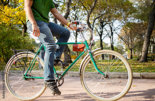 Close-up of young man riding bicycle in park
