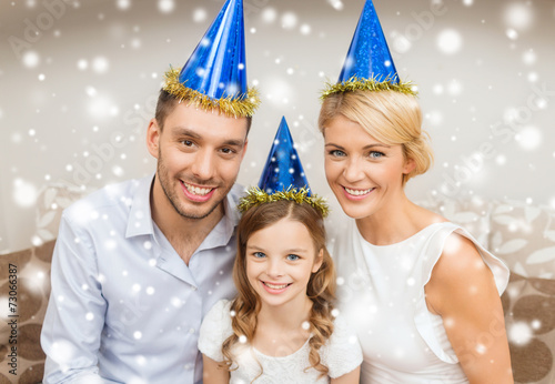 smiling family in party hats at home