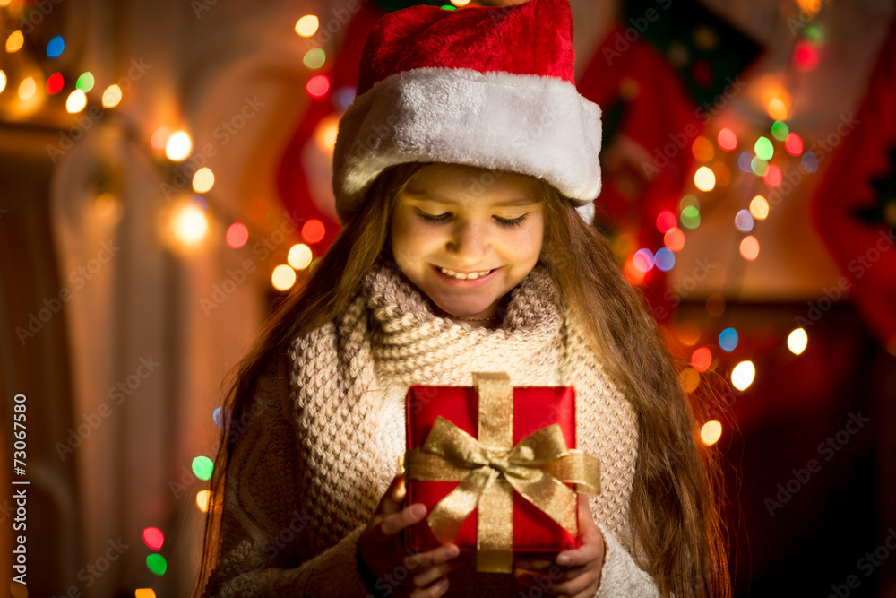 little girl looking at open box with Christmas present