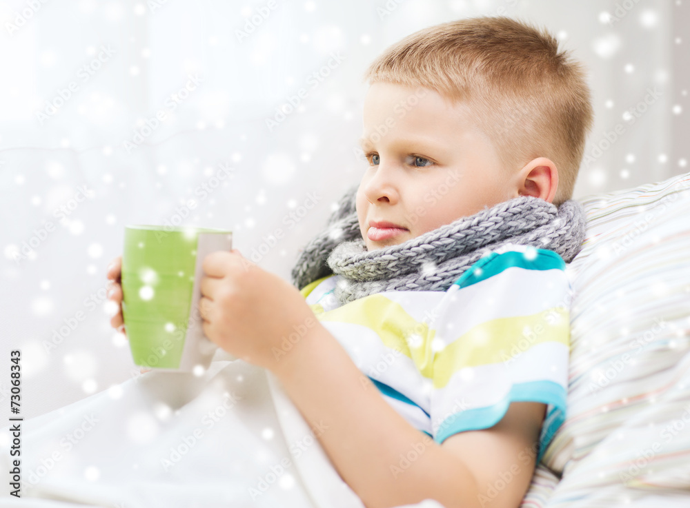 ill boy with flu in bed drinking from cup at home ill boy with flu in bed drinking from cup at home