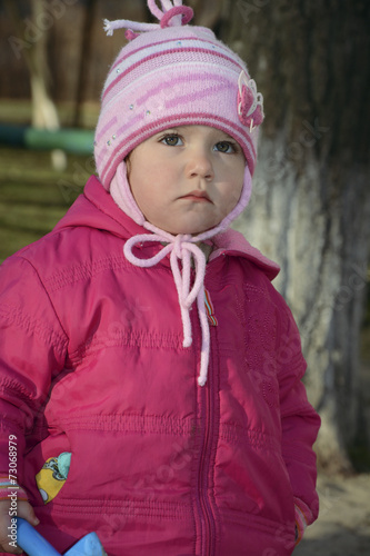 Little upset girl standing alone on a street in the spring. © tsomka
