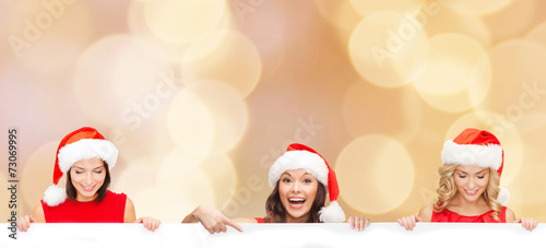 women in santa helper hat with blank white board © Syda Productions